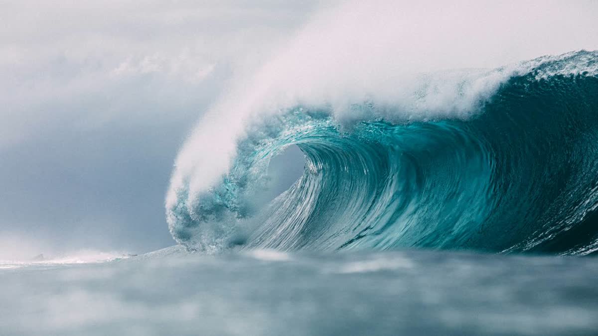 A powerful turquoise ocean wave breaking, used as a metaphor for the next wave of AI research.