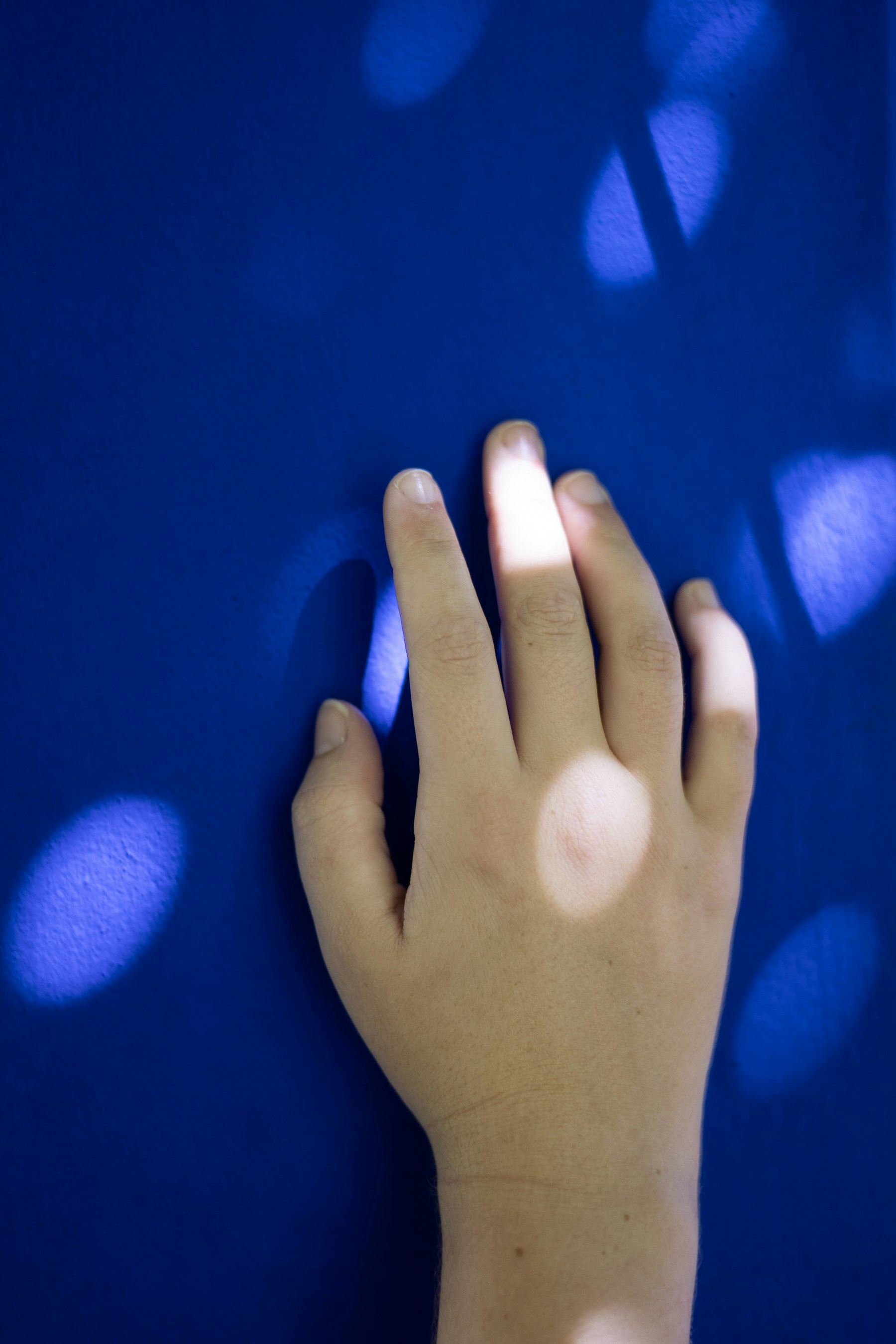 A hand against a blue background, used as a visual cue for touch and embodied interaction.